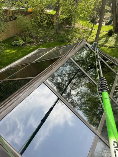 Professional window cleaning by Sparkle Window Cleaners — Angled skylight/glass roof being cleaned with pole